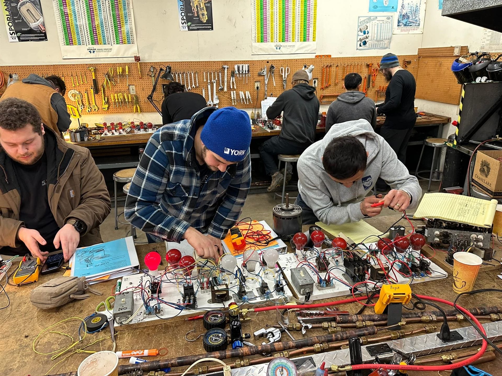 Focused troubleshooting at a training bench with authentic HVAC equipment