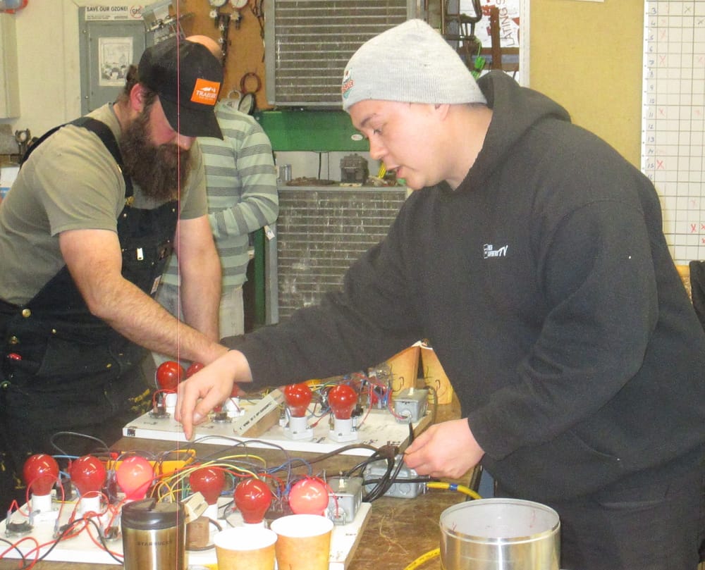 Crawford Engelking instructing at an electrical troubleshooting board in the HVAC School lab